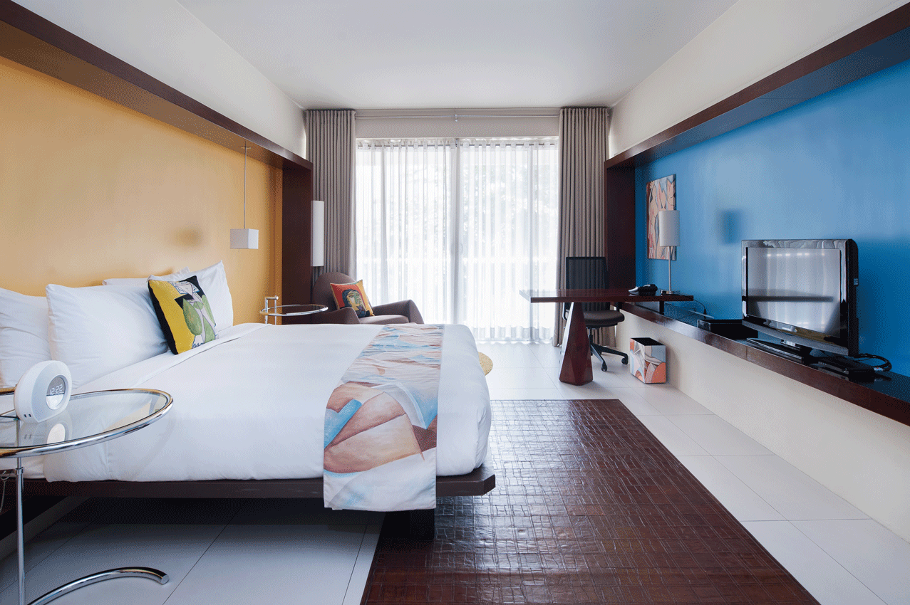 A hotel room with a large bed and a blue wall