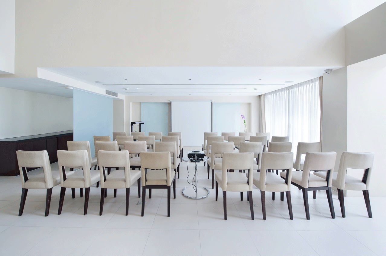 The Picasso conference room with rows of chairs and a projector screen with free printing
