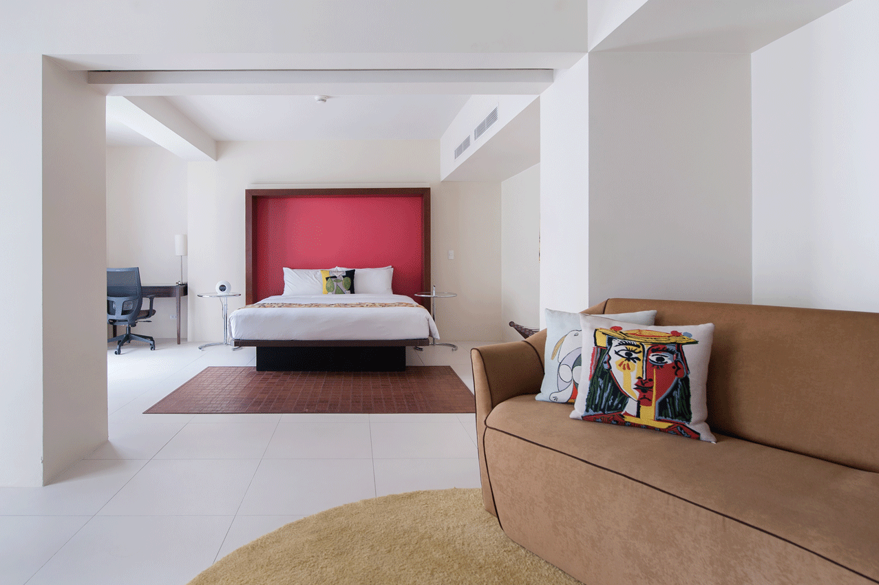 A hotel room with a couch and a bed