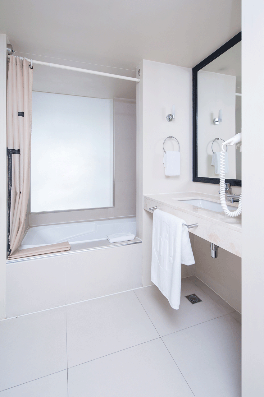 Minimalist bathroom with white fixtures in family-friendly boutique hotel accommodations.