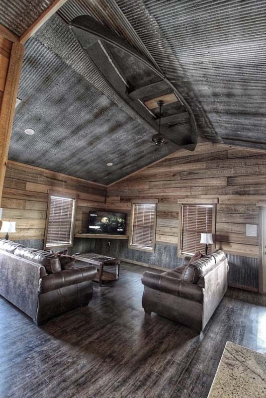 A living room with wooden walls and a corrugated metal ceiling