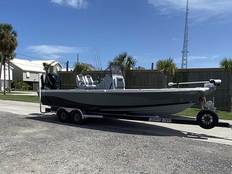 A boat is parked on the side of the road on a trailer.