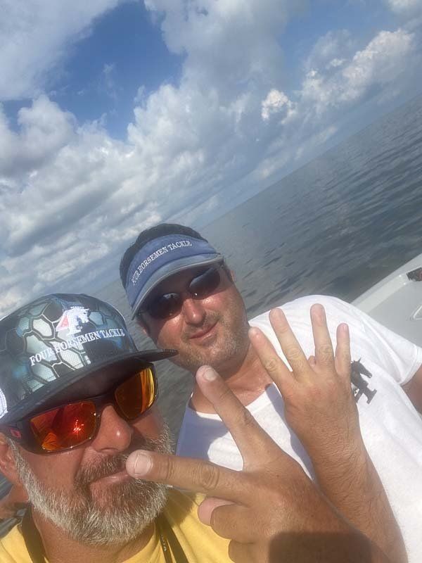 Two men are posing for a picture on a boat in the ocean.