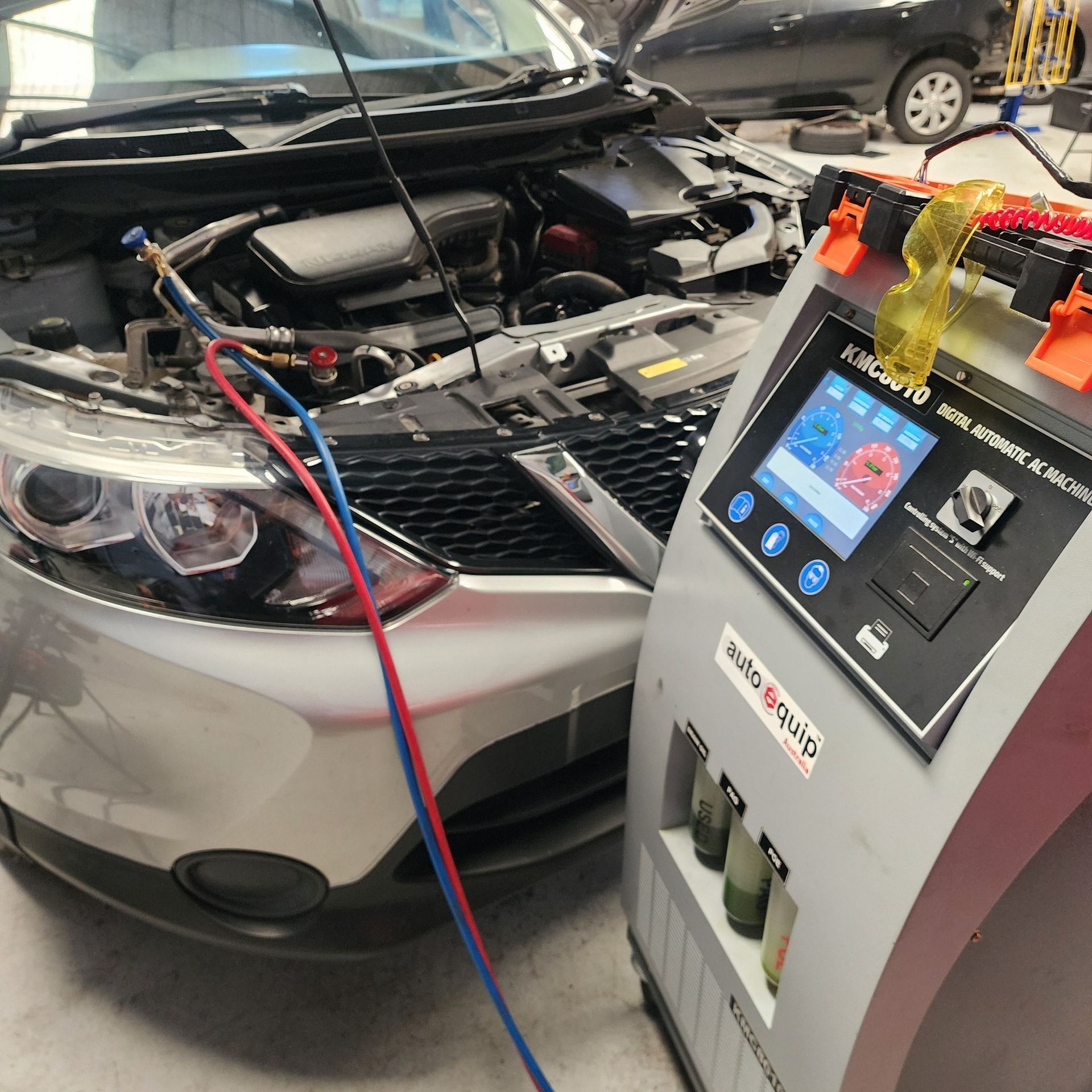 Silver Car With Open Hood Connected to Ac Service Machine in a Garage — QA Oxley in Oxley, QLD