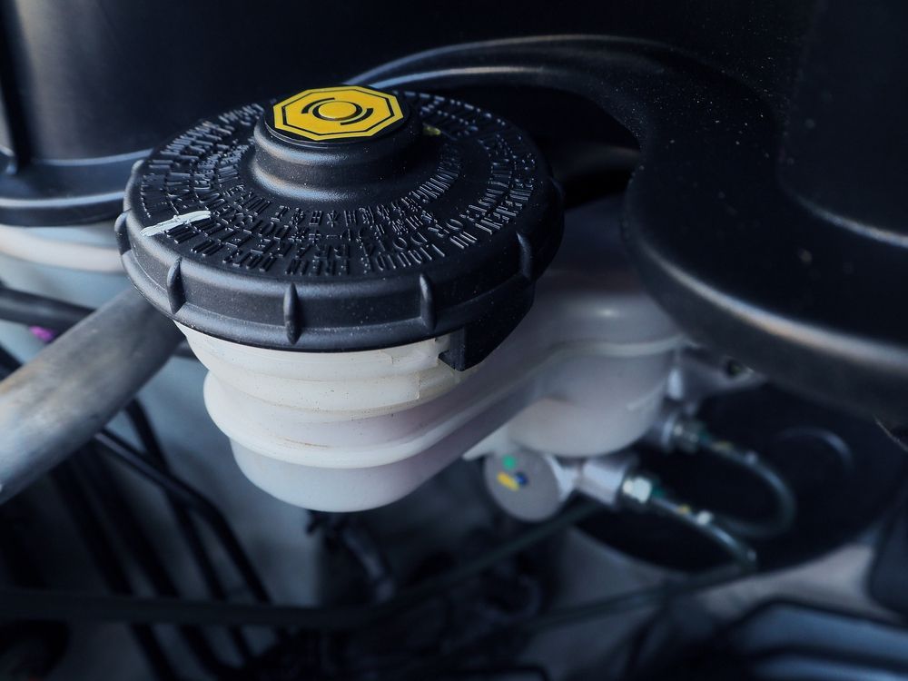 Black Brake Fluid Reservoir With a Yellow Cap in a Car Engine Bay — QA Oxley in Seventeen Mile Rocks, QLD