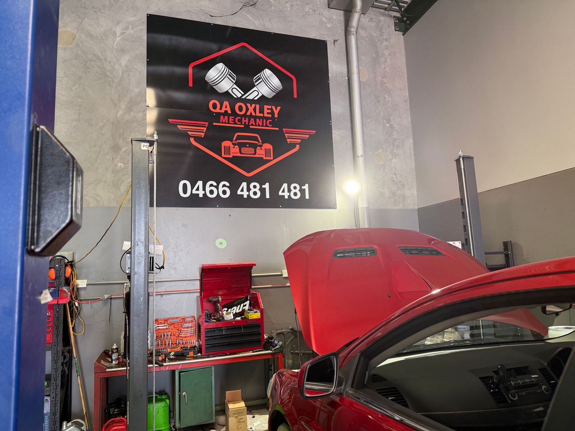 Mechanic Inspecting Car Engine With a Flashlight and Clipboard in a Garage Setting — QA Oxley in Oxley, QLD
