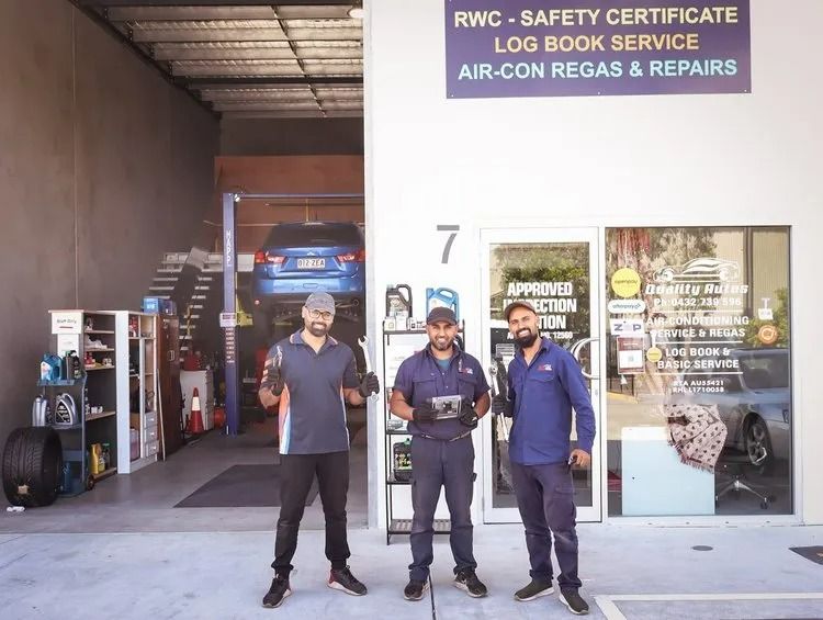 Three Mechanics Smiling in Front of a Garage — QA Oxley in Oxley, QLD