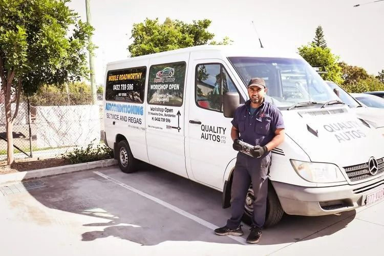 A Man in Work Clothes Stands Next to His White Van Labeled Quality Autos Parked Outdoors — QA Oxley in Oxley, QLD