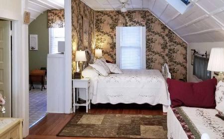 A bedroom with two beds and a ceiling fan