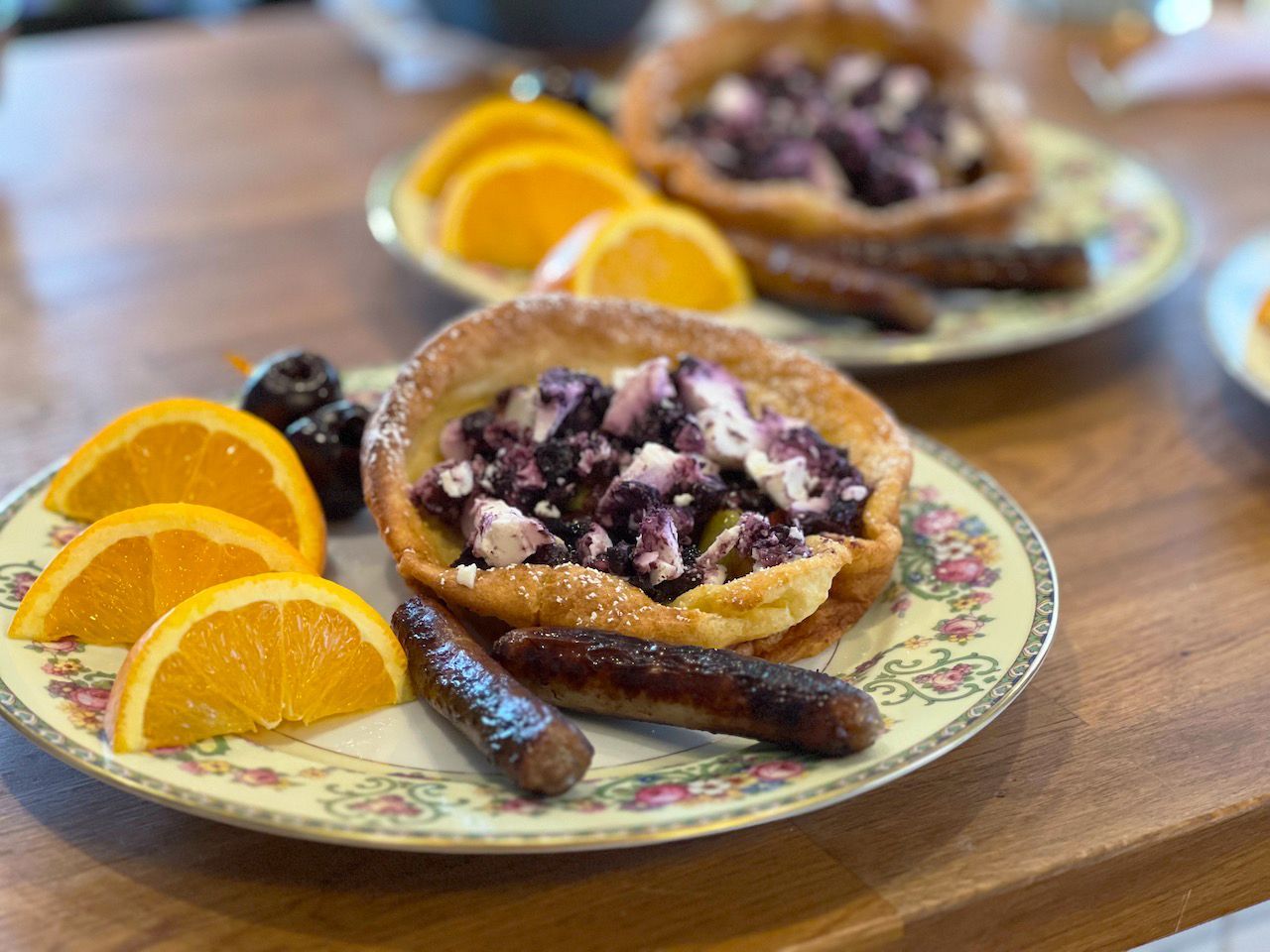 A plate of food with oranges and sausages on a table.