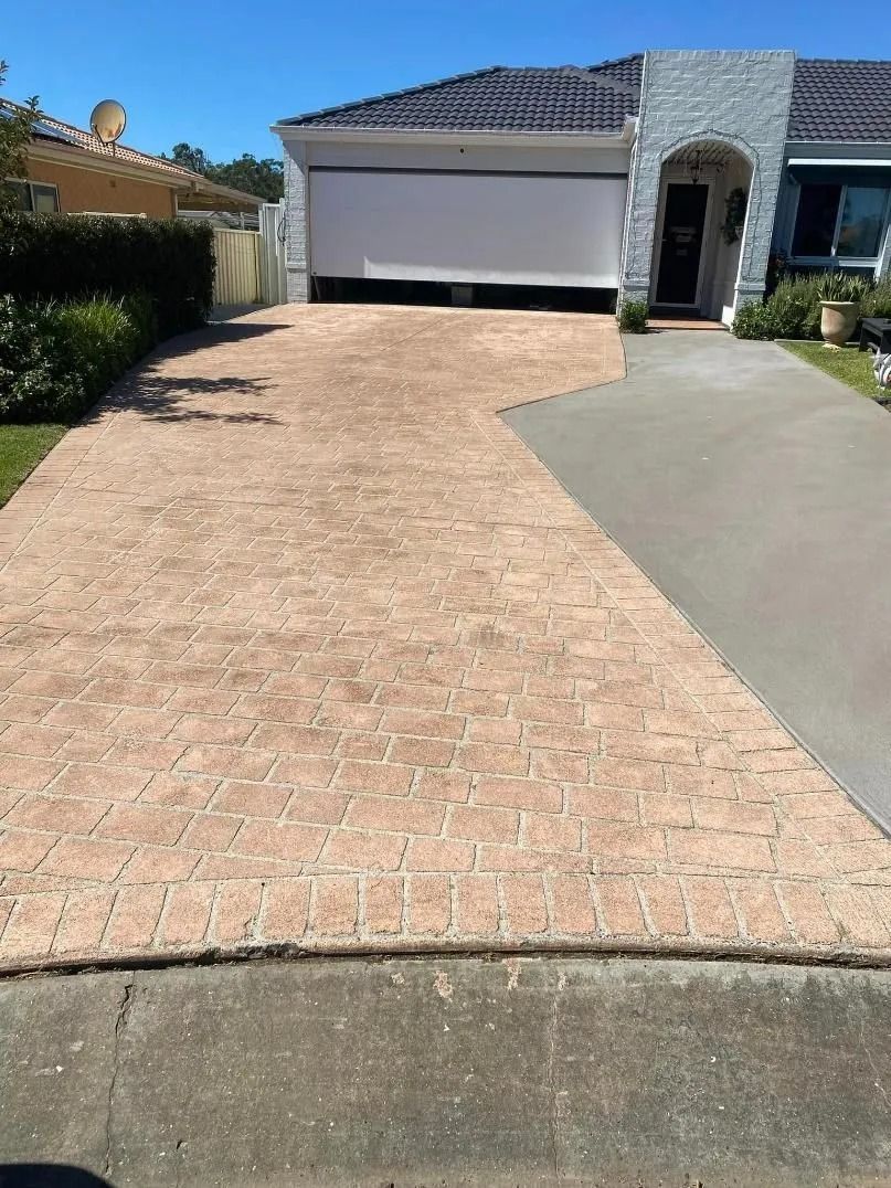 Suburban Driveway With Brick Paving and a Closed Garage — BJ's Concreting in Huskisson, NSW
