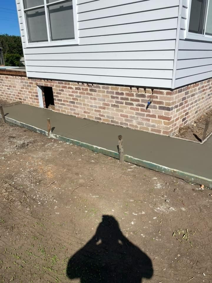 House Foundation With Brick Skirt, Green Waterproofing Strip, and Dirt Yard — BJ's Concreting in Sanctuary Point, NSW