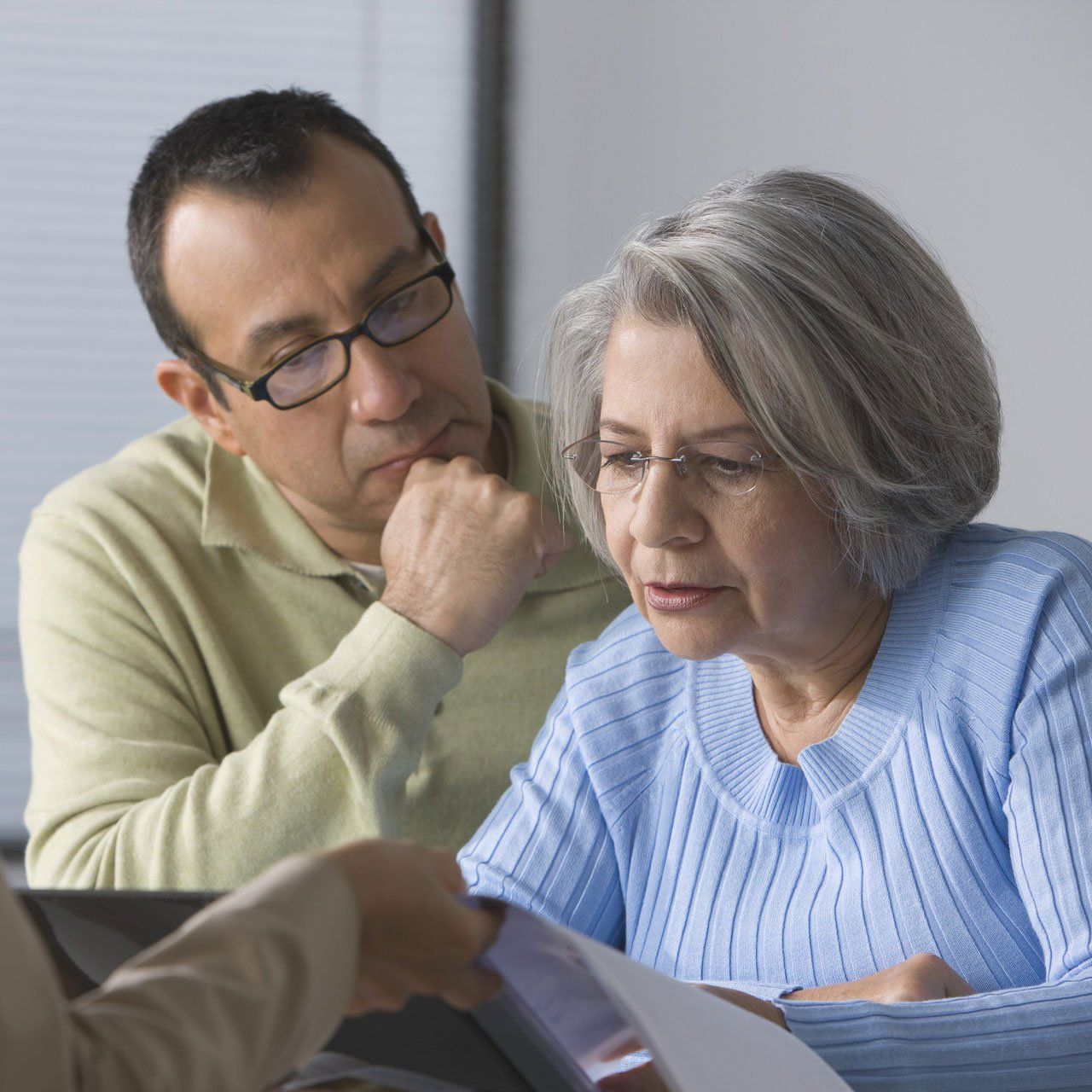 Hispanic man helping mother read Will contract