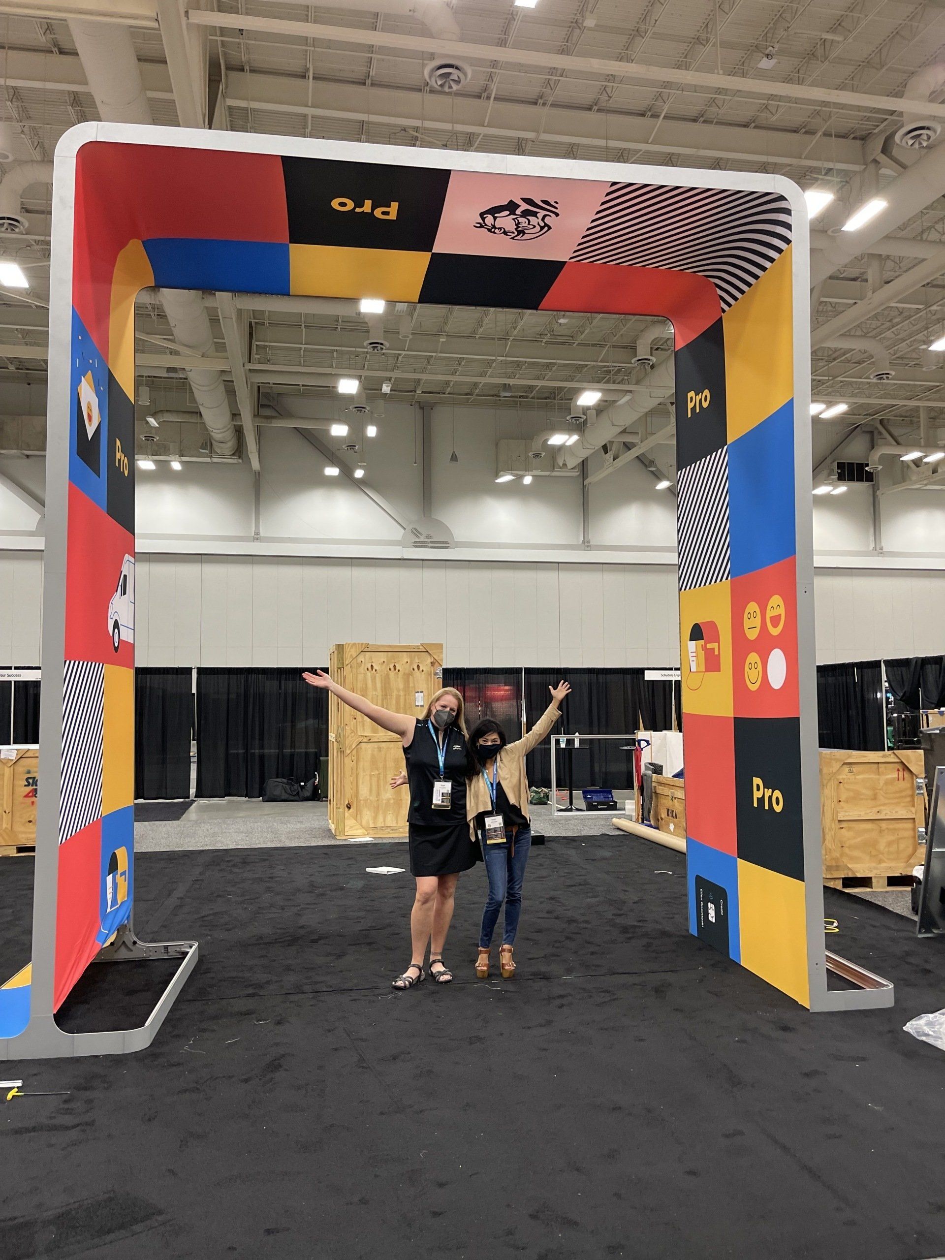 A man and a child are standing under a colorful archway