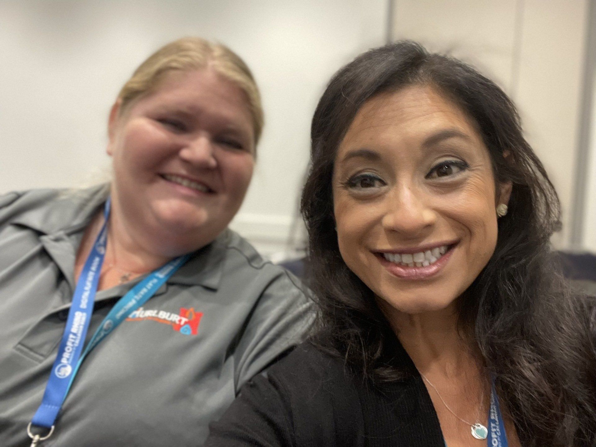 Two women are posing for a picture together and smiling for the camera.