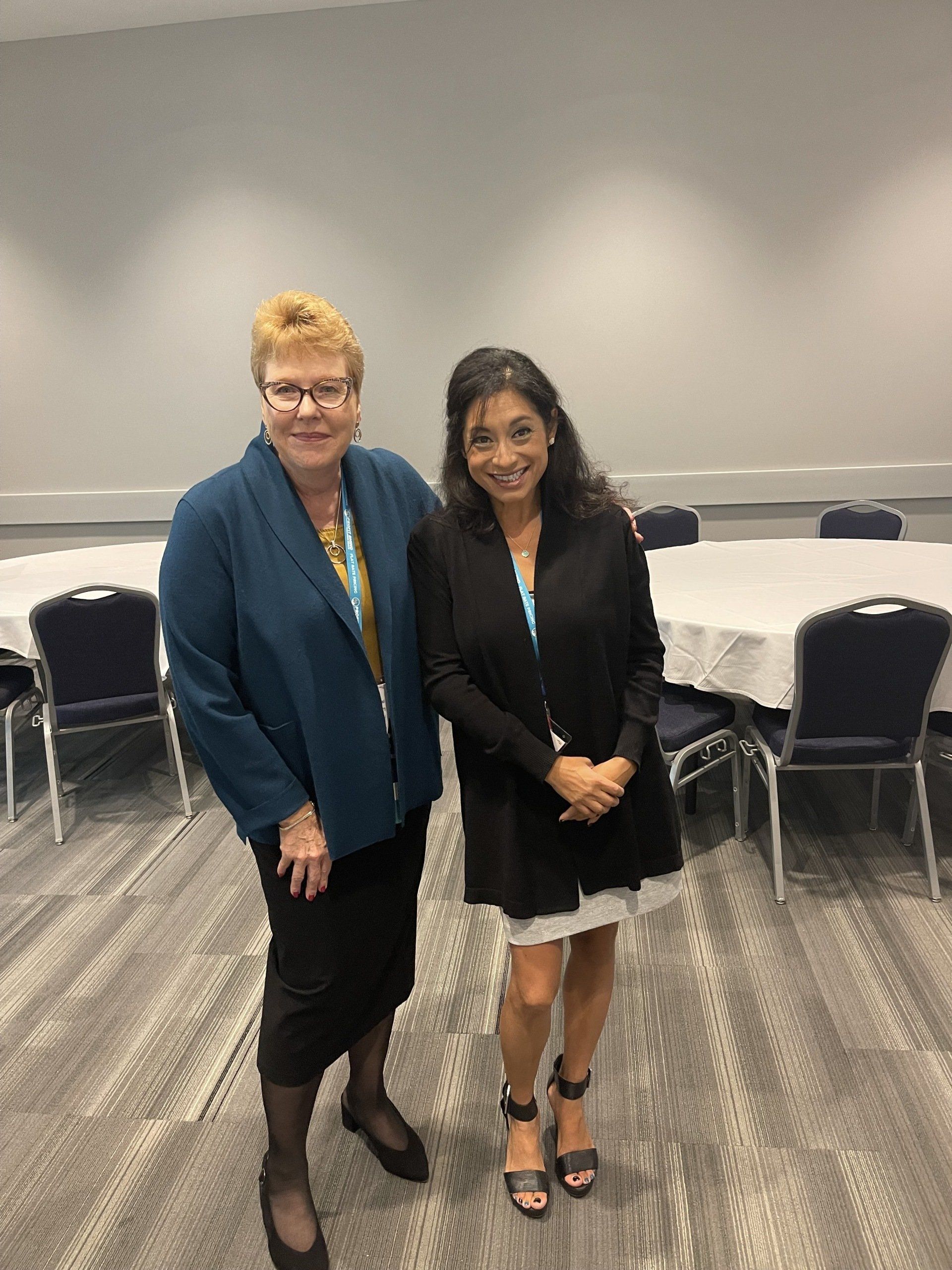 Two women are standing next to each other in a room.