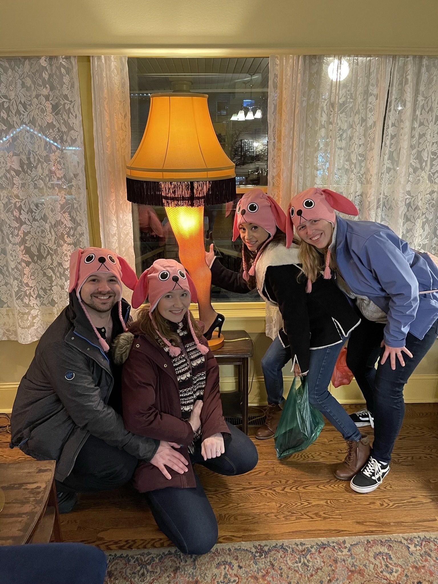 A group of people are posing for a picture in front of a lamp.