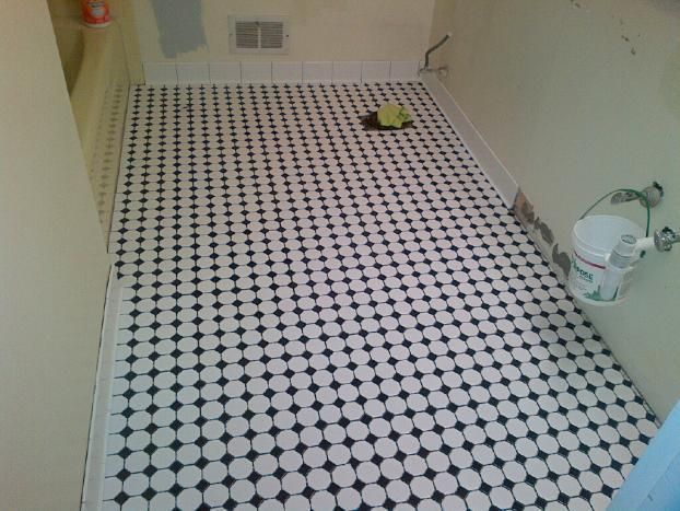 A bathroom with a black and white tile floor.