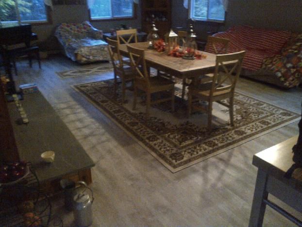 A living room with a table and chairs and a rug