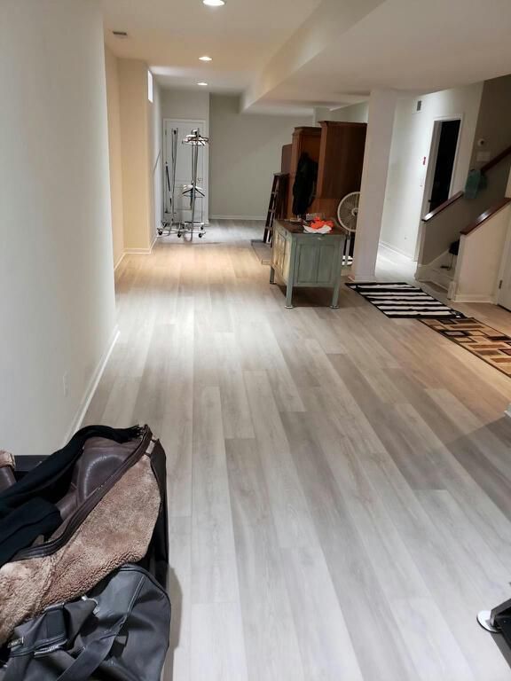 A bag is sitting on the floor in a hallway in a basement.