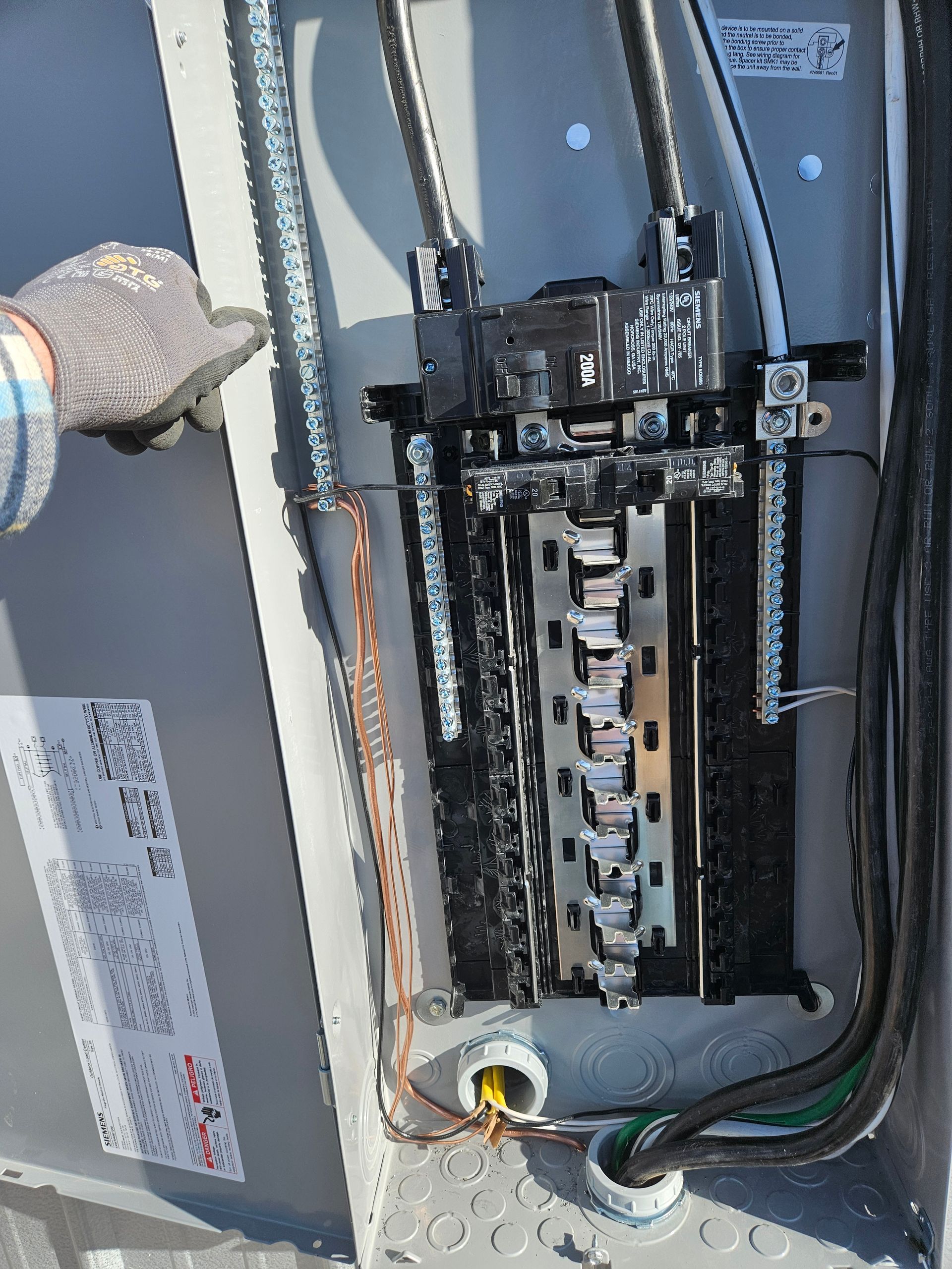 A person is working on an electrical box with a label that says ' a & a ' on it