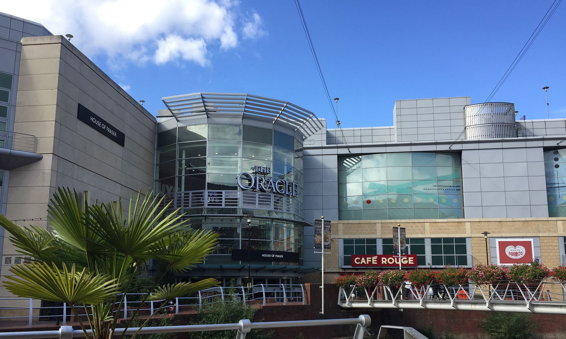 Building exterior with Cafe, glass facade, blue sky.