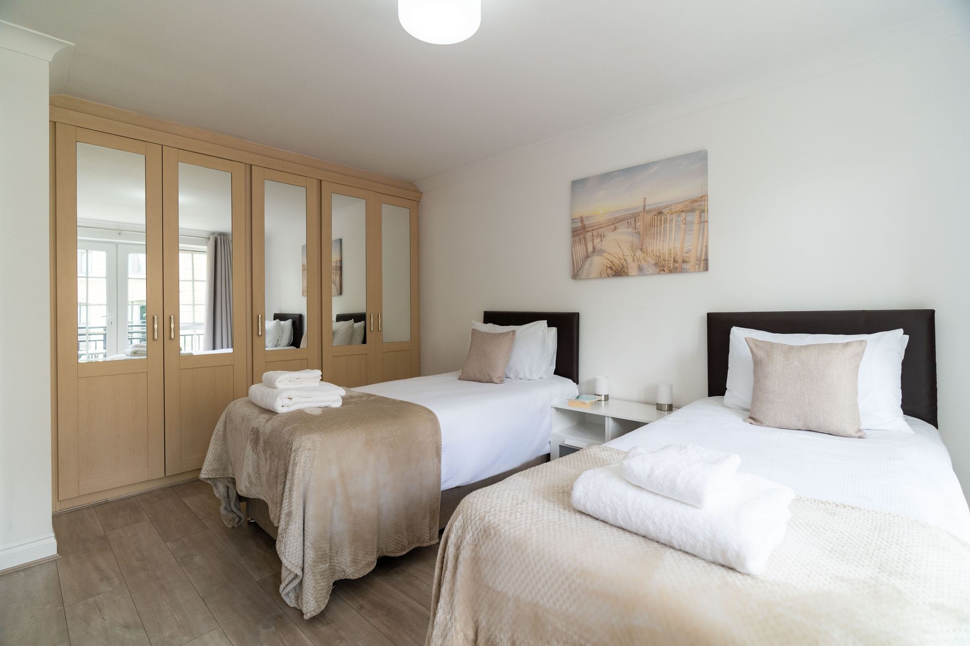 Riverside House twin bedroom with open doors 