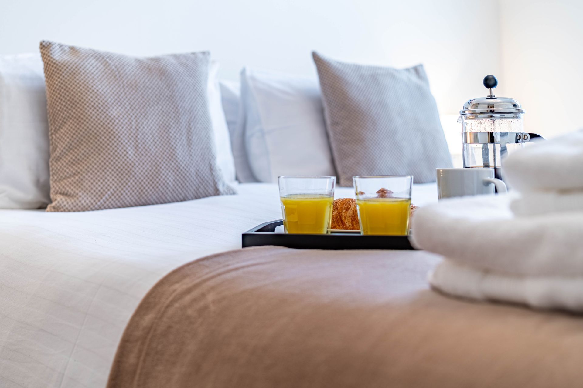 Riverside House double bed with a breakfast tray and folded towels 