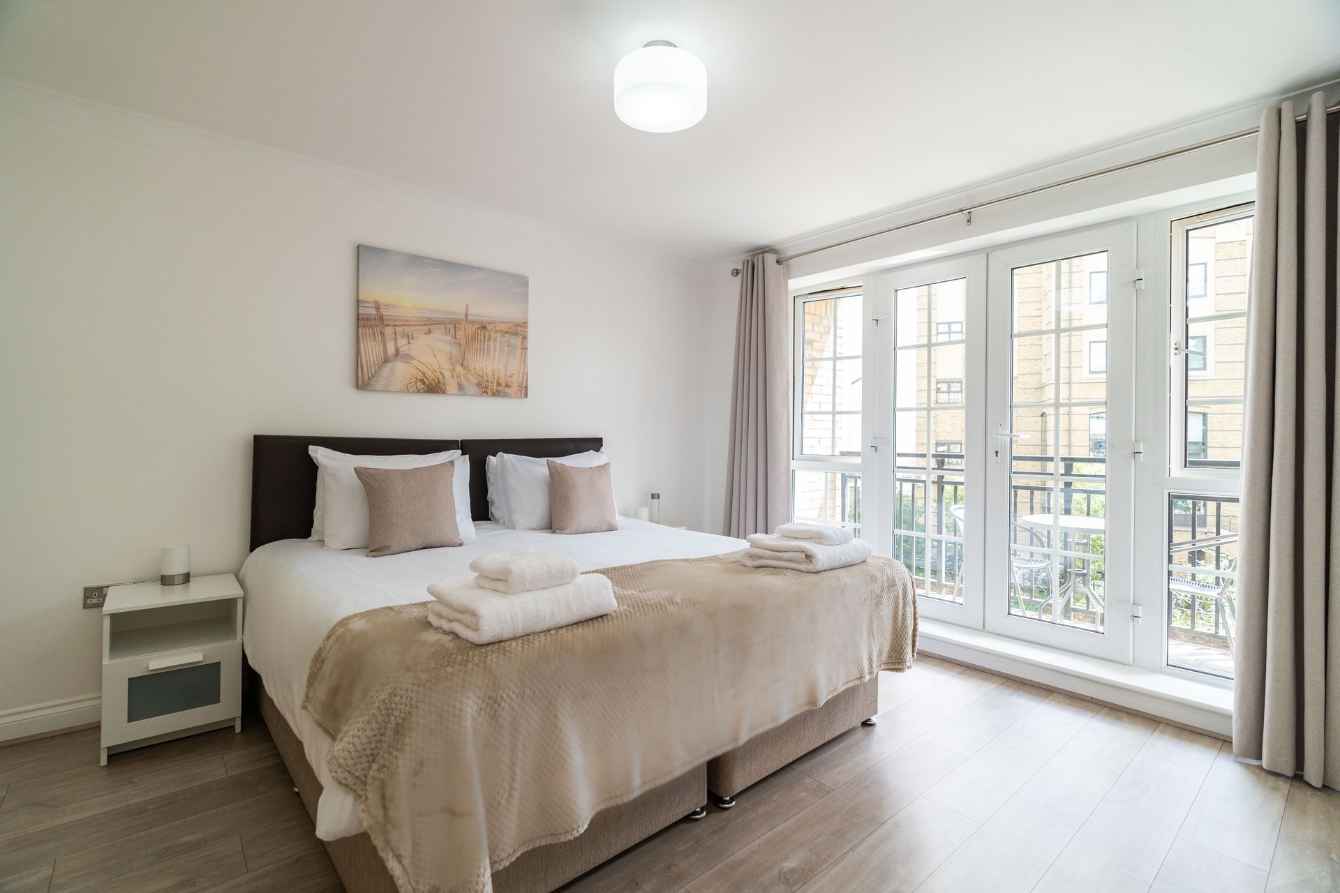riverside house master bedroom with folded towels on the bed and breakfast tray 