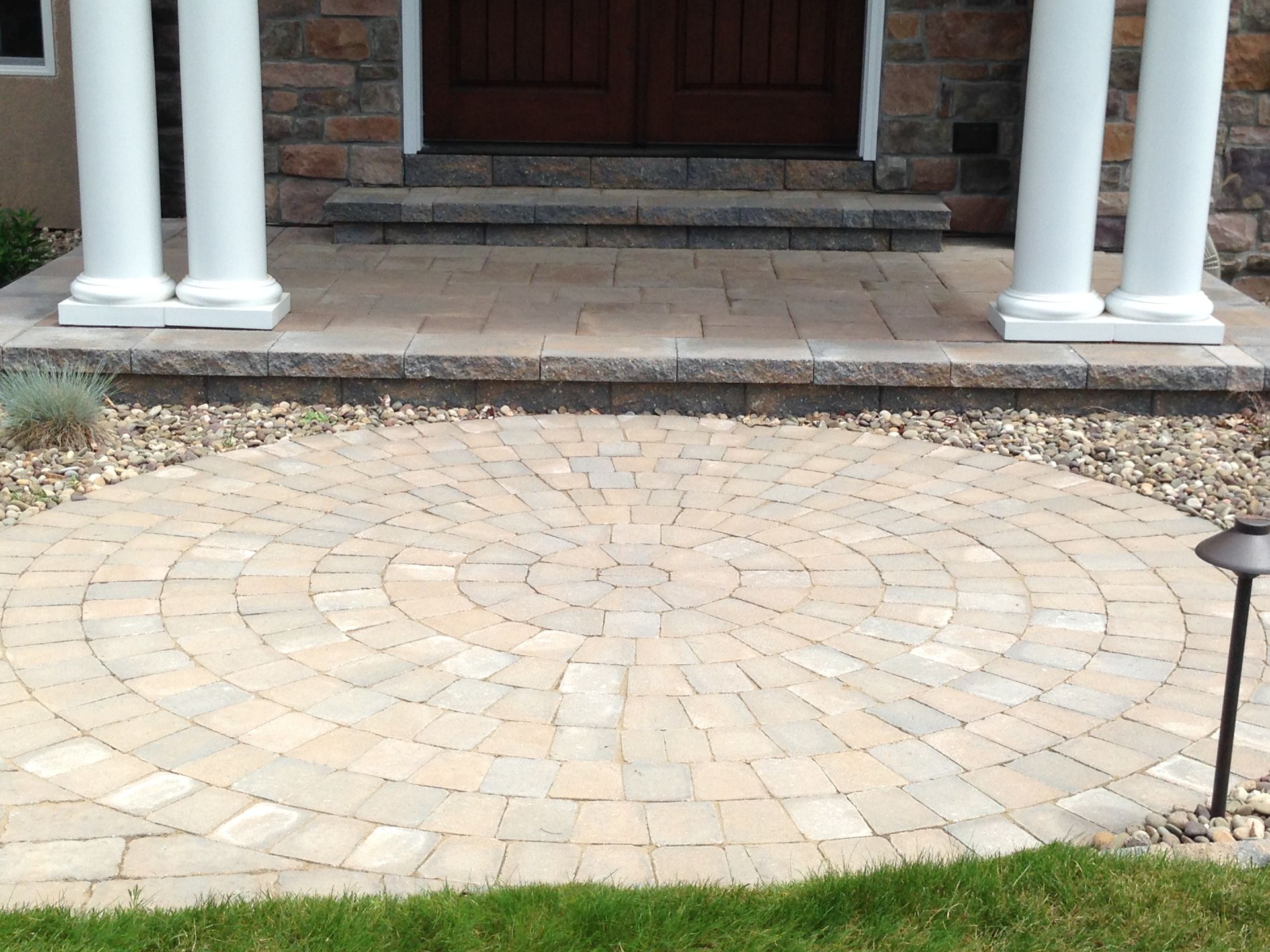 Circular brick patio leading to a home's entrance, flanked by columns and steps Mechanicsburg, PA.