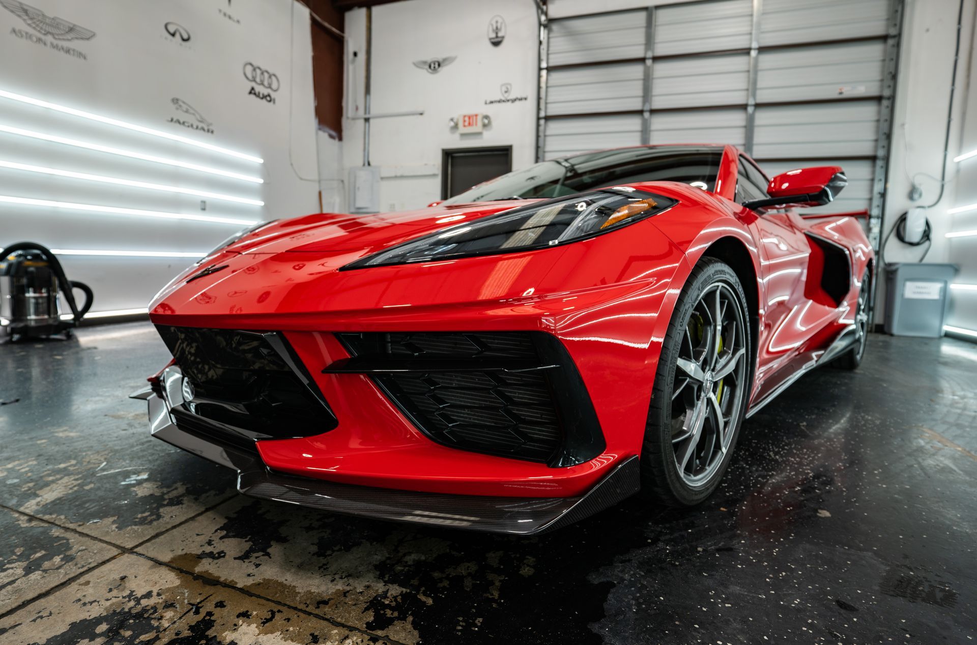 A red sports car is parked in a garage.