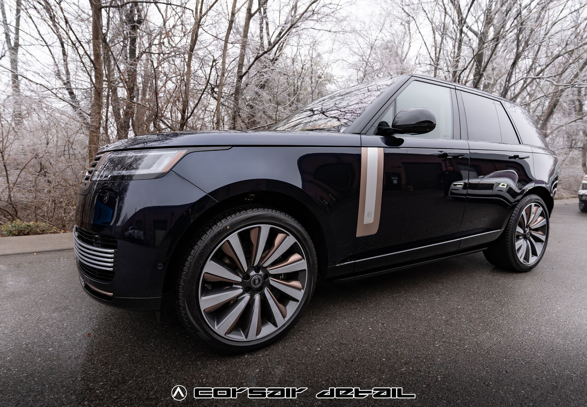 A black range rover is parked on the side of the road.