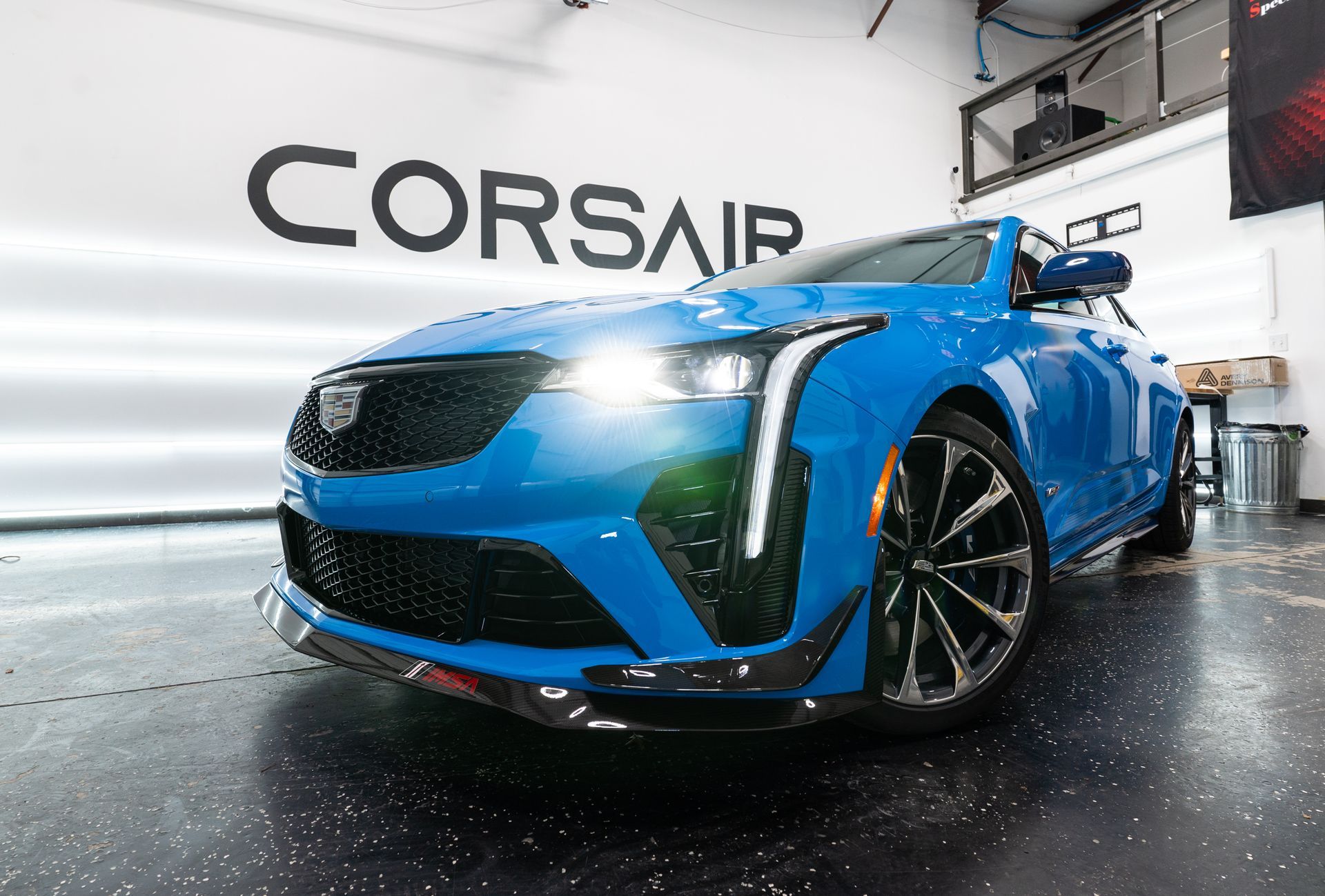 A blue cadillac corsair is parked in a garage.