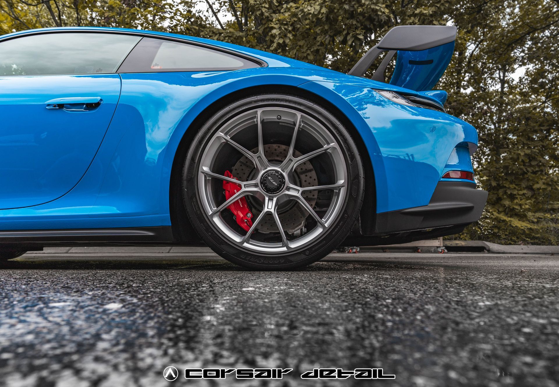 A blue sports car is parked on the side of the road.