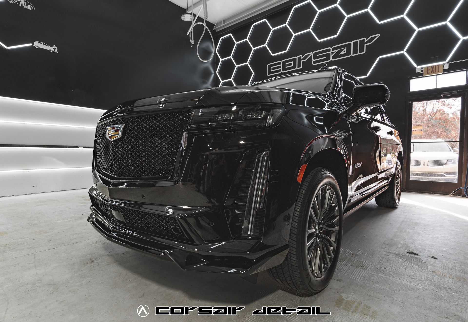 A black cadillac is parked in a car wash