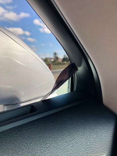 A close up of a car window with a blue sky in the background