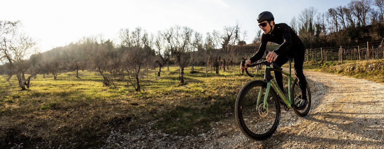 A Man Is Riding A Bike On A Dirt Road — Trinity Cycle Works In Cairns City, QLD