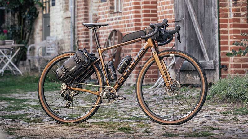 A Gold Bicycle Is Sitting In Front Of A Brick House On Grass— Trinity Cycle Works In Cairns City, QLD