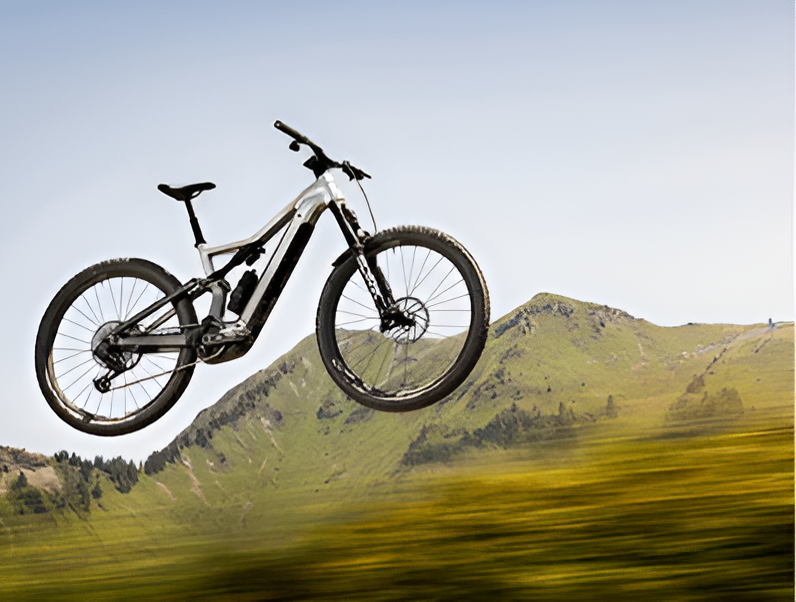 An Electric Bike Is Jumping In The Air In Front Of A Mountain — Trinity Cycle Works In Cairns City, QLD