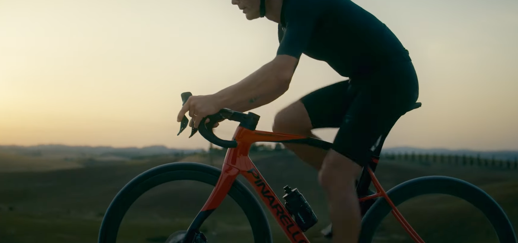 A Man Is Riding A Bicycle On A Country Road At Sunset — Trinity Cycle Works In Cairns City, QLD