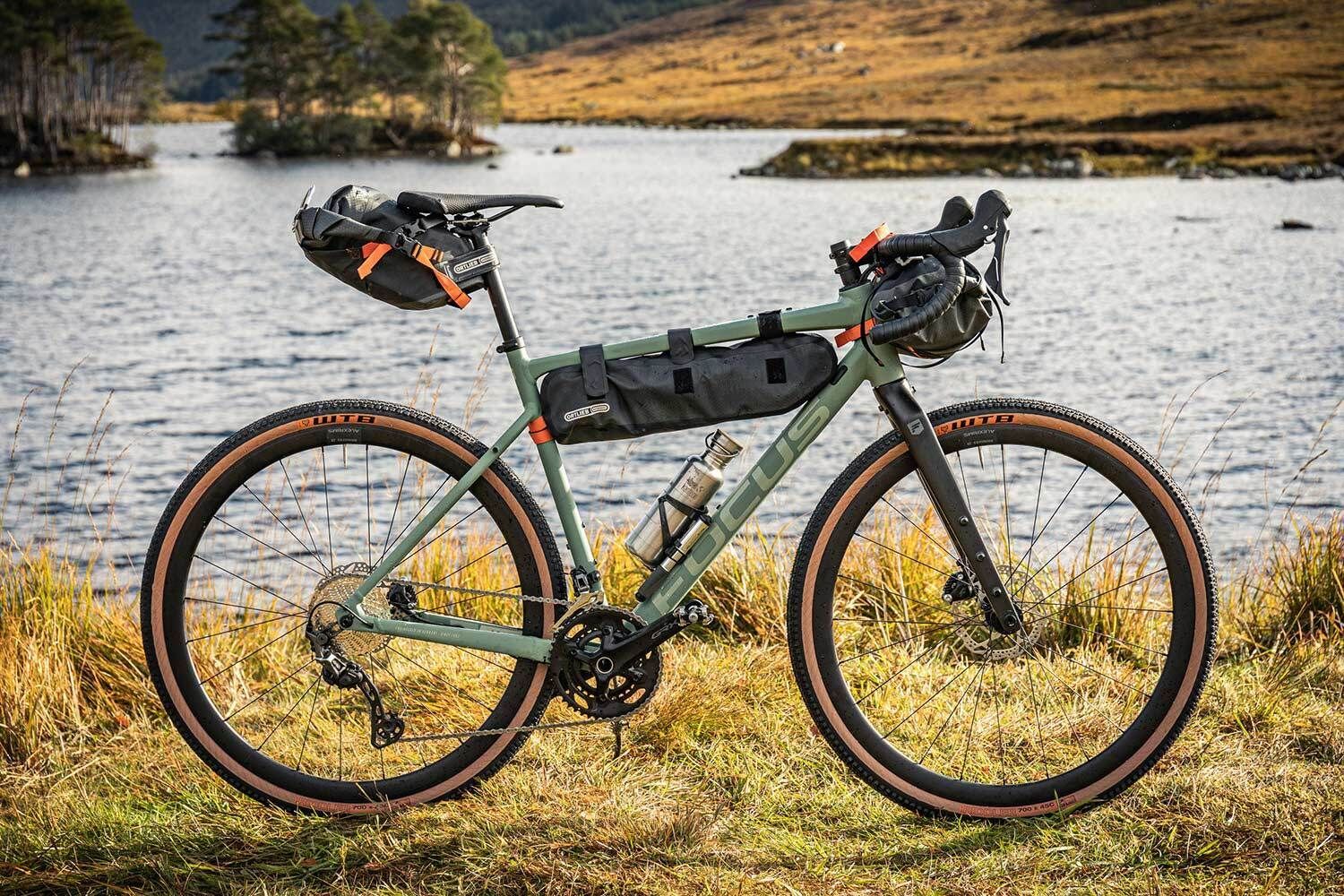 A Bicycle Is Parked In The Grass Next To A Body Of Water — Trinity Cycle Works In Cairns City, QLD