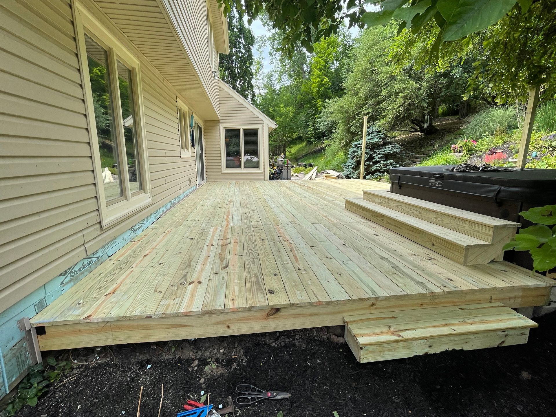 A wooden deck is being built in front of a house.