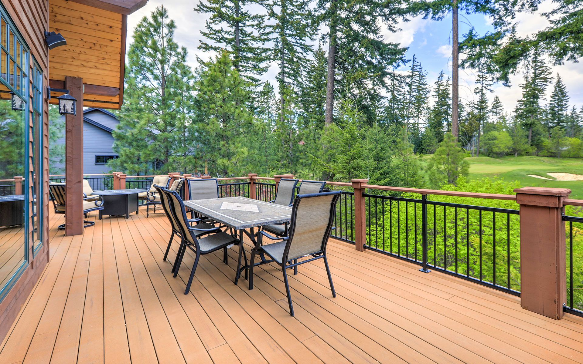 There is a large deck with a table and chairs on it.