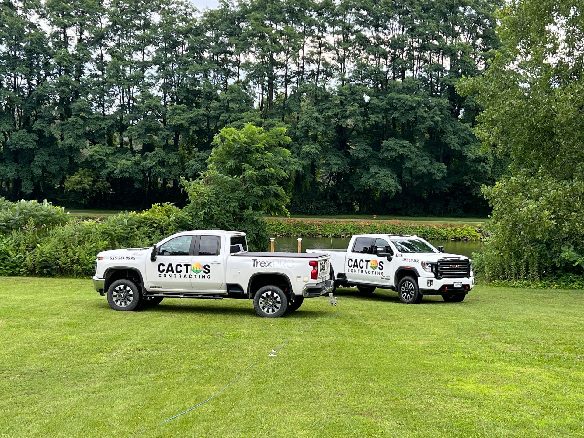 Two trucks are parked next to each other in a grassy field.