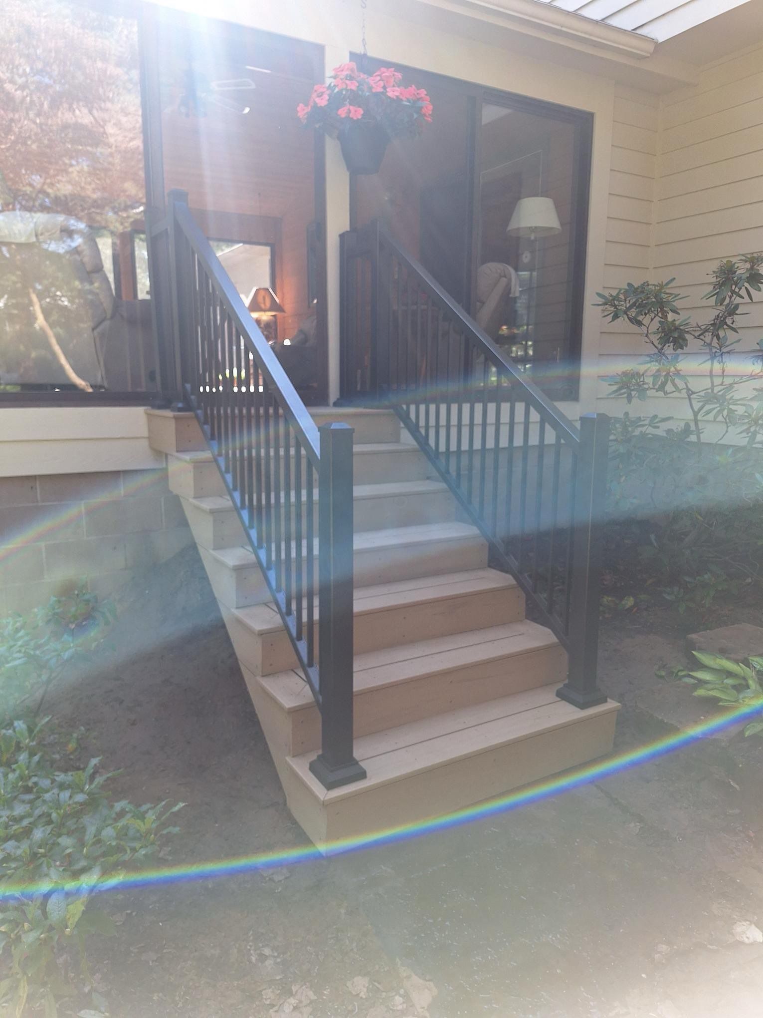 A set of stairs leading up to a porch with a railing.
