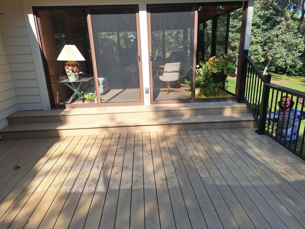 A deck with sliding glass doors leading to a screened in porch