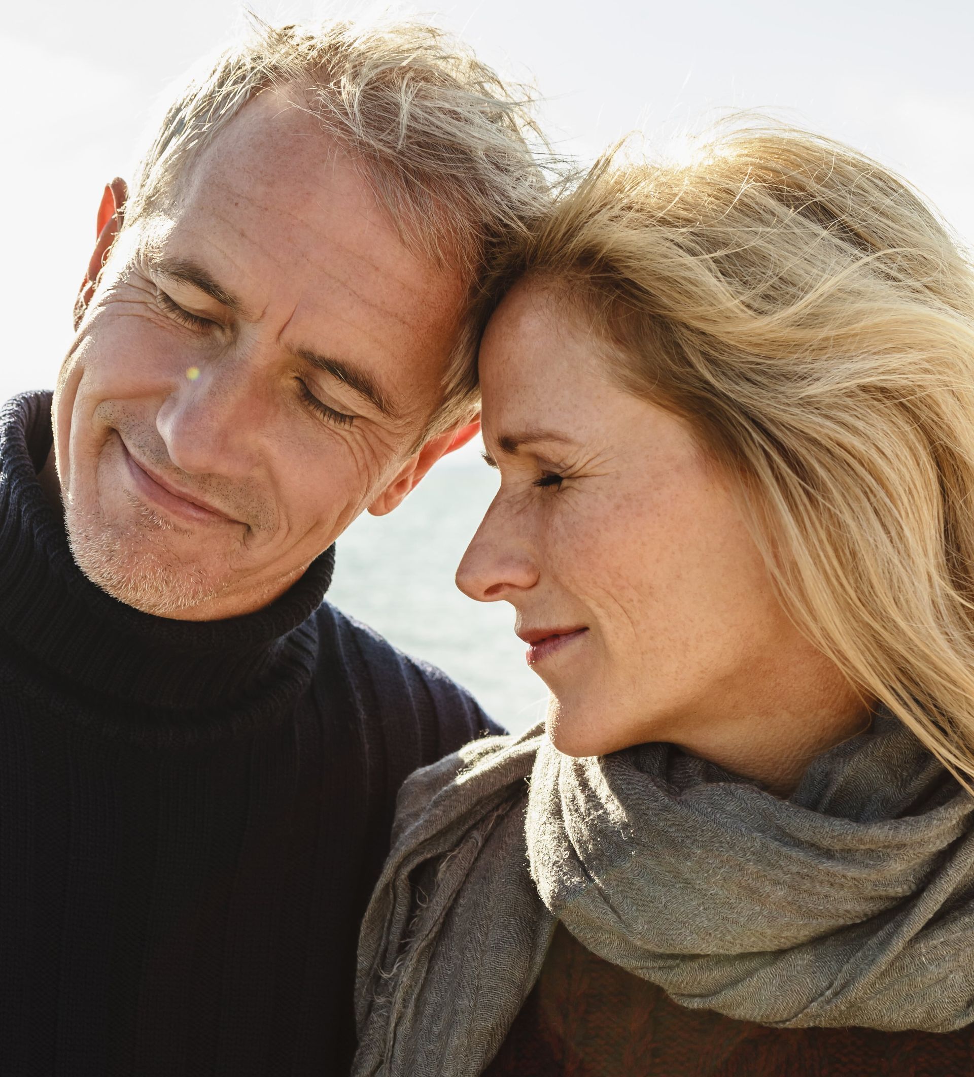 A man and a woman are looking at each other with their eyes closed.