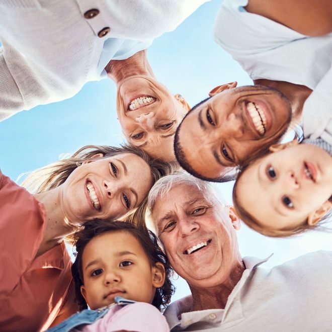 A group of people are standing in a circle and smiling at the camera.