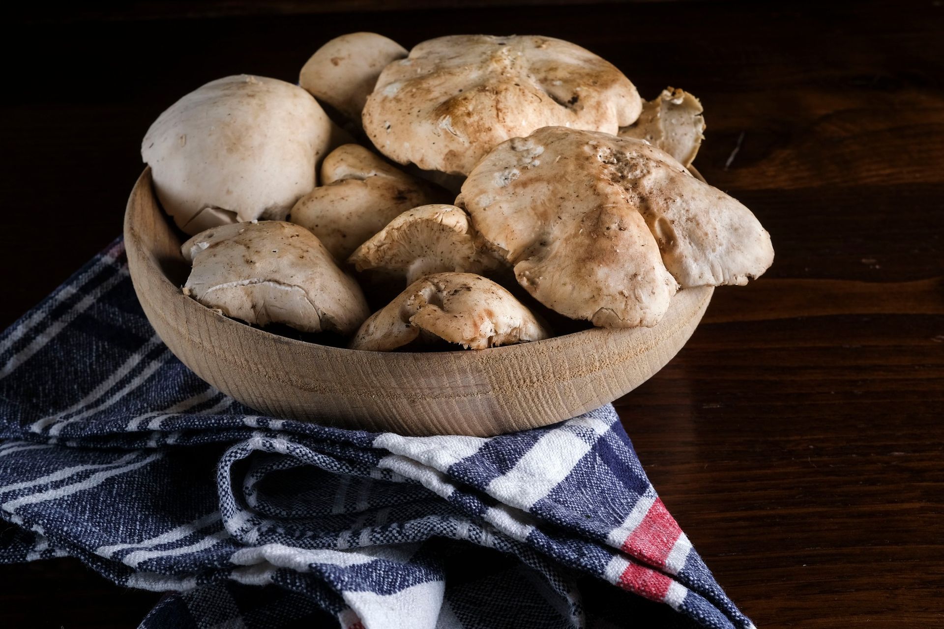 Una ciotola di legno piena di funghi 