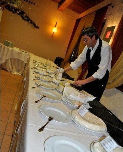 Un cameriere sta preparando il cibo su un lungo tavolo